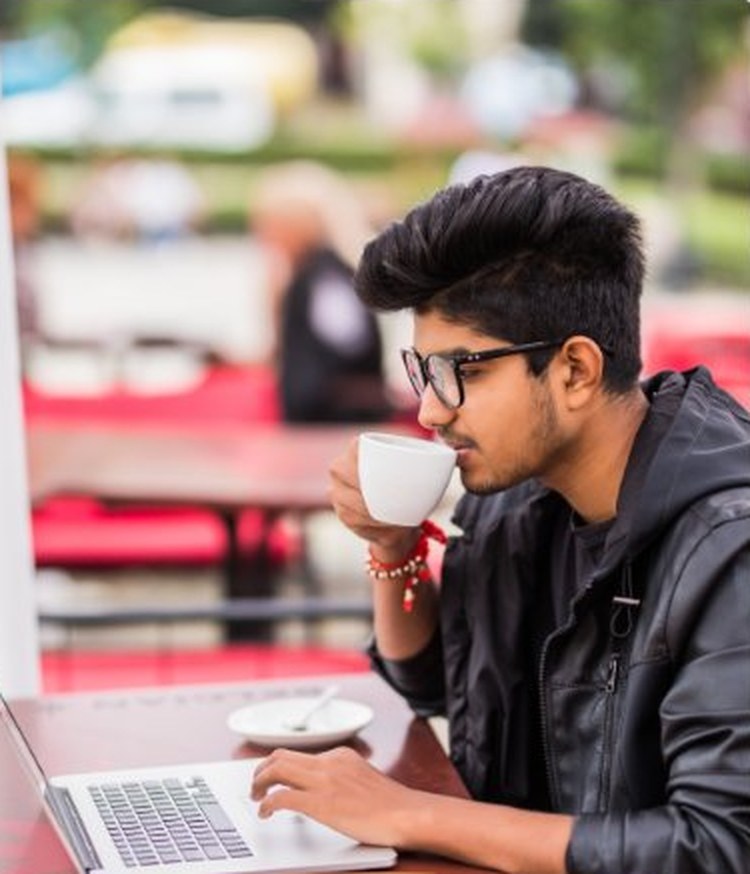 MITSDE learner studying on a laptop at a café